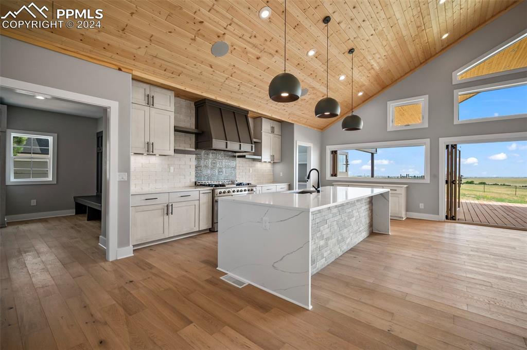 18775 Sweet Road Peyton, CO 80831 - Photo 9 of 50 a large kitchen with stainless steel appliances granite countertop a lot of cabinets and wooden floor