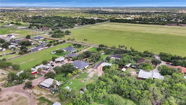 an aerial view of ocean and residential houses with outdoor space