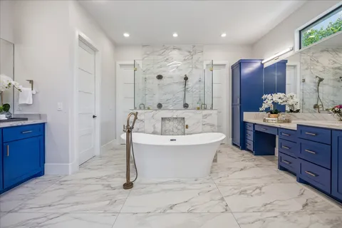 a spacious bathroom with a tub sink and mirror