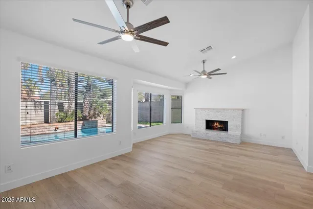 a view of an empty room with a fireplace and a window