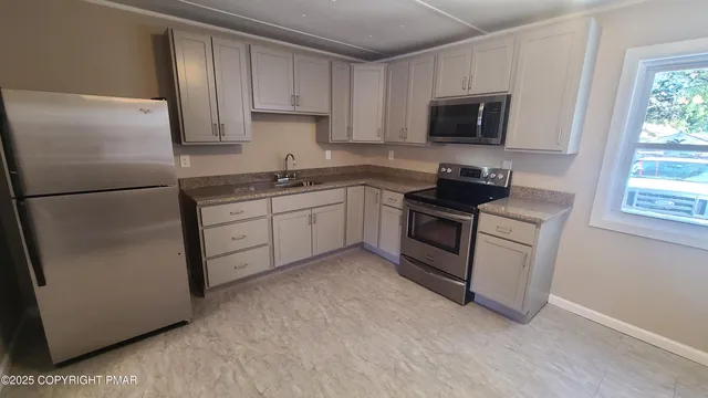 a kitchen with cabinets stainless steel appliances and a sink