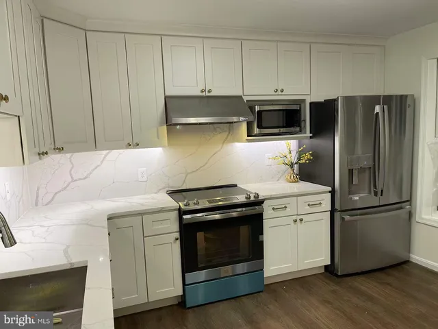 a kitchen with stainless steel appliances white cabinets and a stove