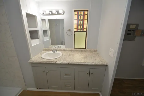 a bathroom with a granite countertop sink and a mirror
