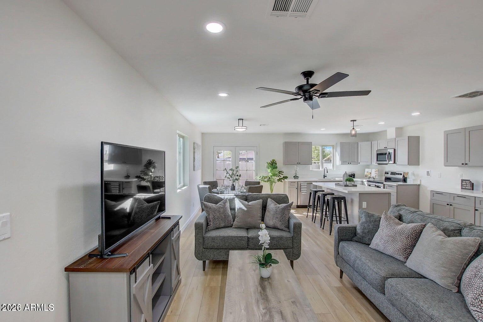 2509 East Broadway Road Phoenix, AZ 85040 - Photo 19 of 47 a living room with furniture kitchen area and a flat screen tv