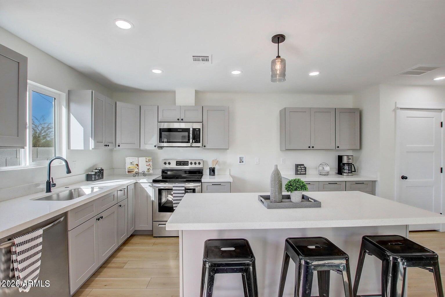 2509 East Broadway Road Phoenix, AZ 85040 - Photo 24 of 47 a kitchen with a sink a stove and chairs