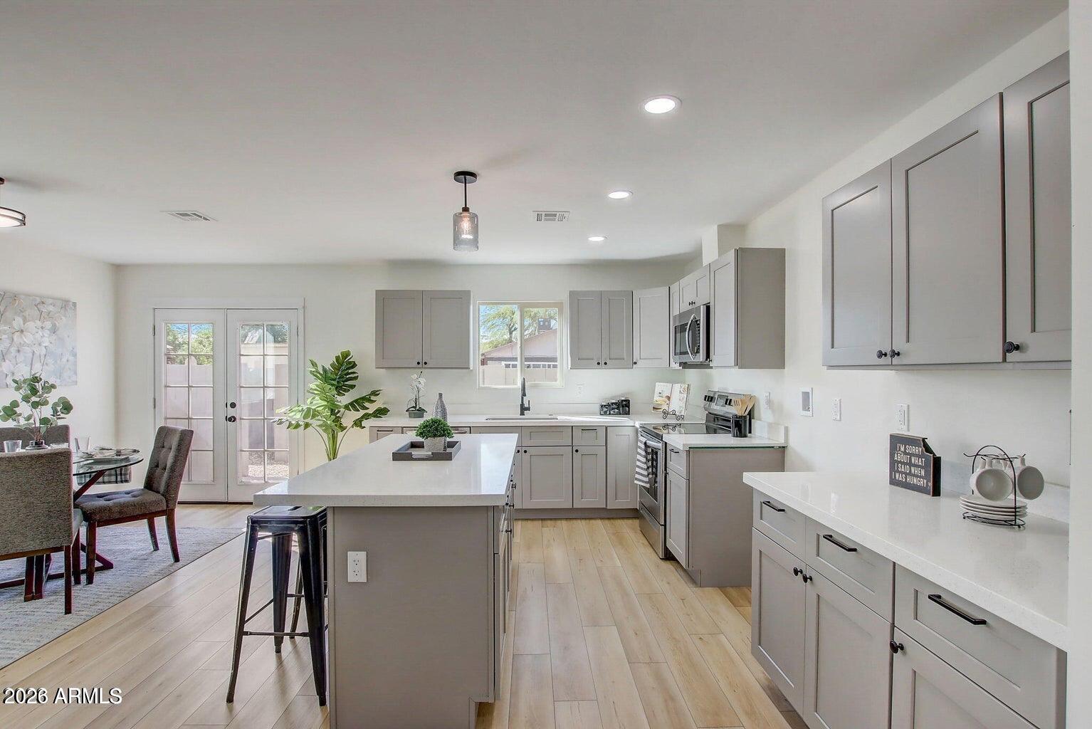 2509 East Broadway Road Phoenix, AZ 85040 - Photo 4 of 47 a kitchen with a sink stove cabinets and wooden floor