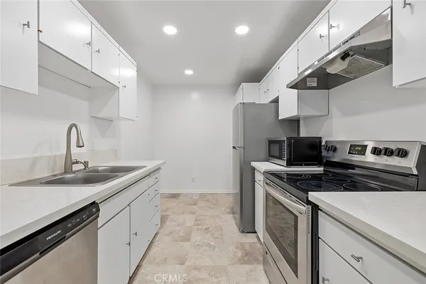 a kitchen with stainless steel appliances granite countertop a sink stove and cabinets