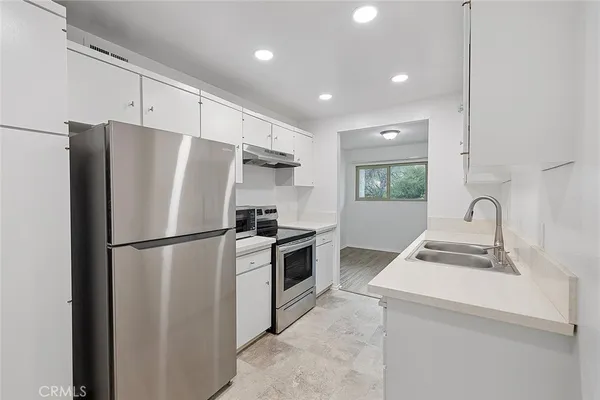 a kitchen with a refrigerator sink and stove