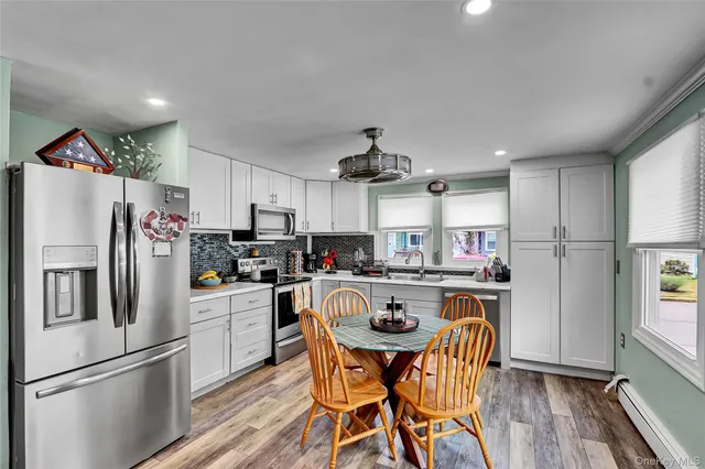 a kitchen with refrigerator a stove and wooden floor