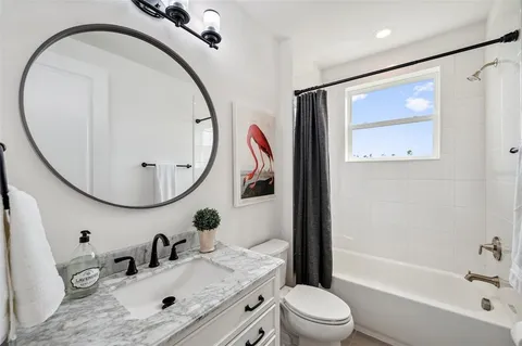 a view of a white house with a big yard and potted plants