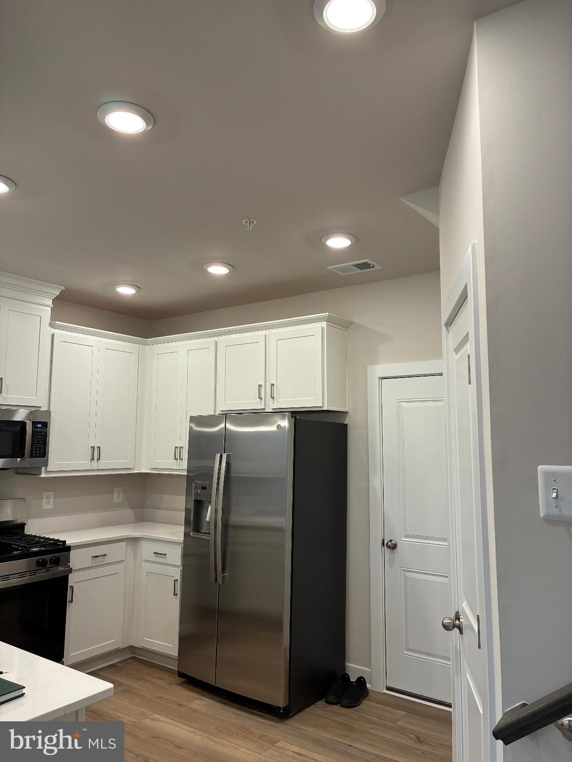 20823 Cloongee Terrace Sterling, VA 20166 - Photo 9 of 12 a kitchen with a refrigerator and white cabinets