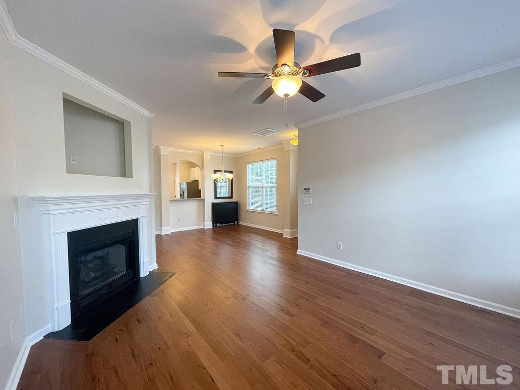 7841 Silverthread Lane Raleigh, NC 27617 - Photo 3 of 15 a view of an empty room with wooden floor and a fireplace