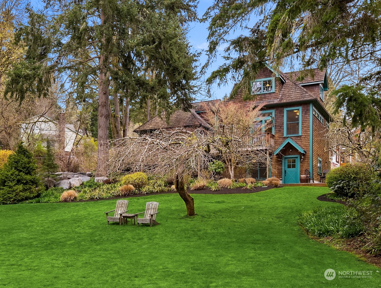 a front view of a house with a garden and trees