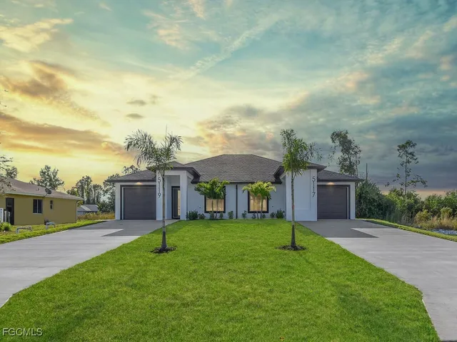 a view of a house with a yard and sitting area