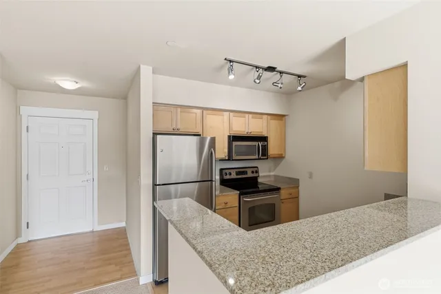 a kitchen with kitchen island a counter top space appliances and cabinets