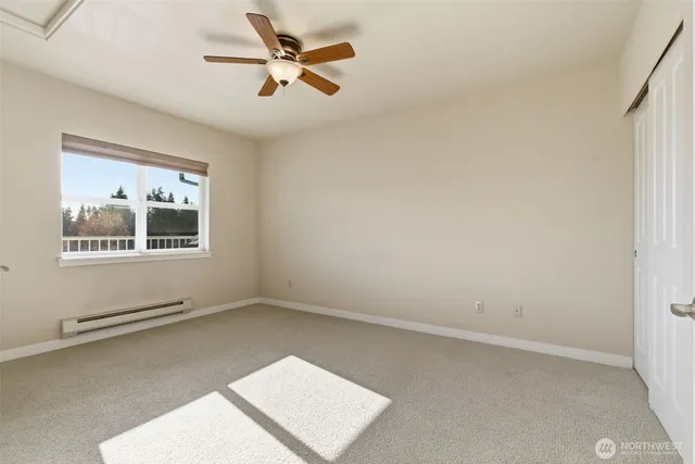 an empty room with a window and a ceiling fan