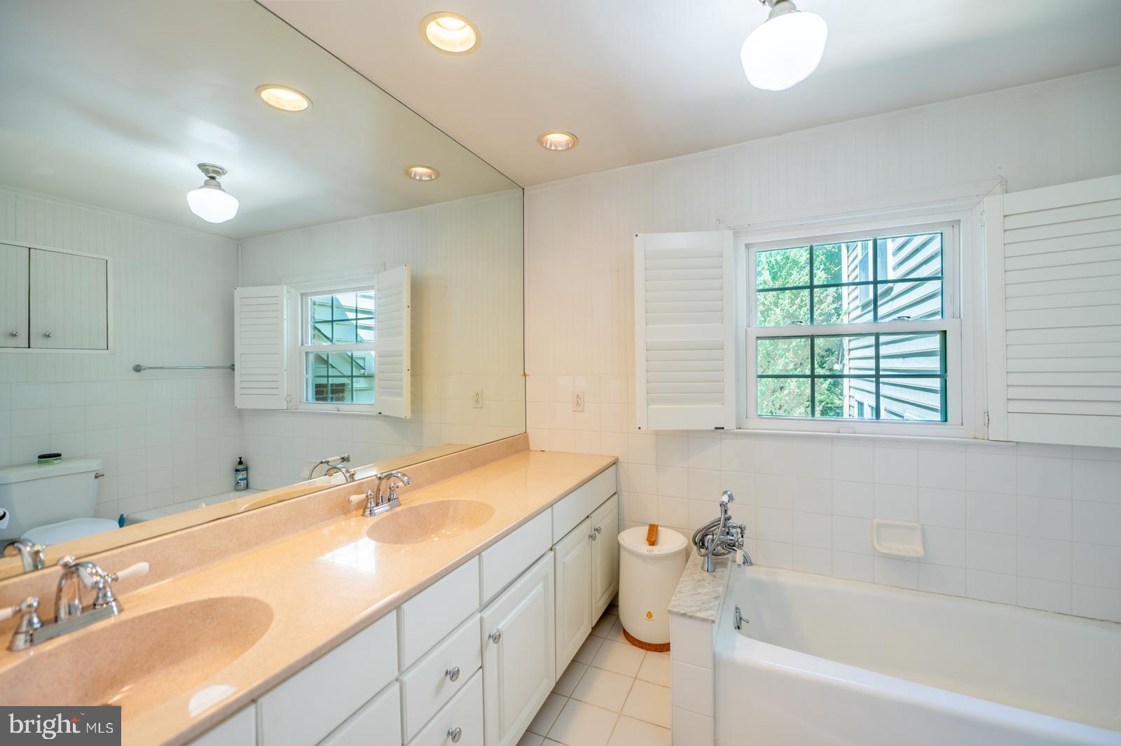 22 Salisbury Lane Malvern, PA 19355 - Photo 30 of 57 a bathroom with a granite countertop sink mirror bathtub and next to a window