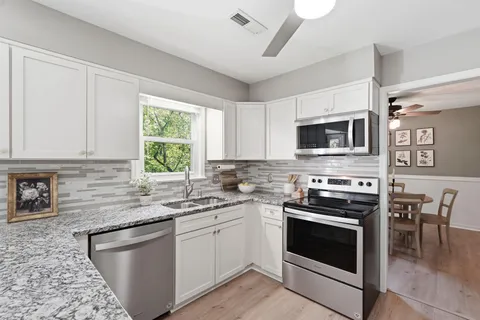 a kitchen with stainless steel appliances a stove sink microwave and cabinets
