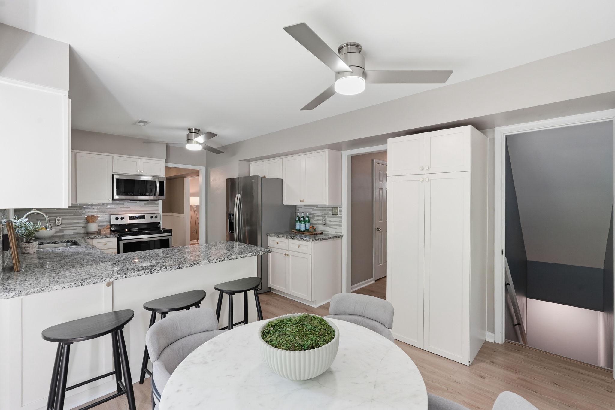124 Oaklawn Road Stafford, VA 22554 - Photo 15 of 36 a kitchen with stainless steel appliances kitchen island granite countertop a refrigerator a sink a stove a dining table and chairs