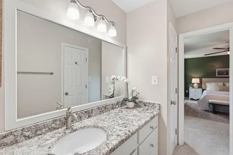 a bathroom with a granite countertop sink and a mirror