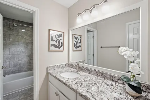 a bathroom with a granite countertop sink a toilet and shower