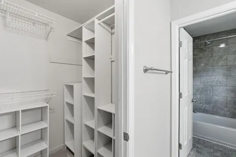 a bathroom with a bathtub and a walk in closet