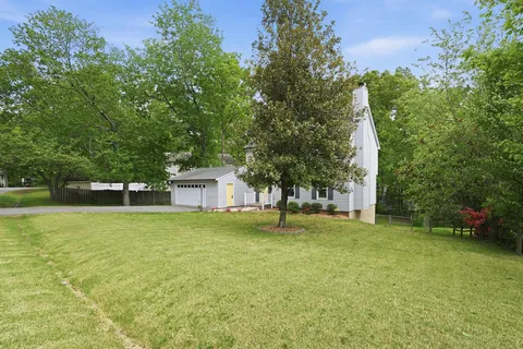 a front view of a house with a yard and trees