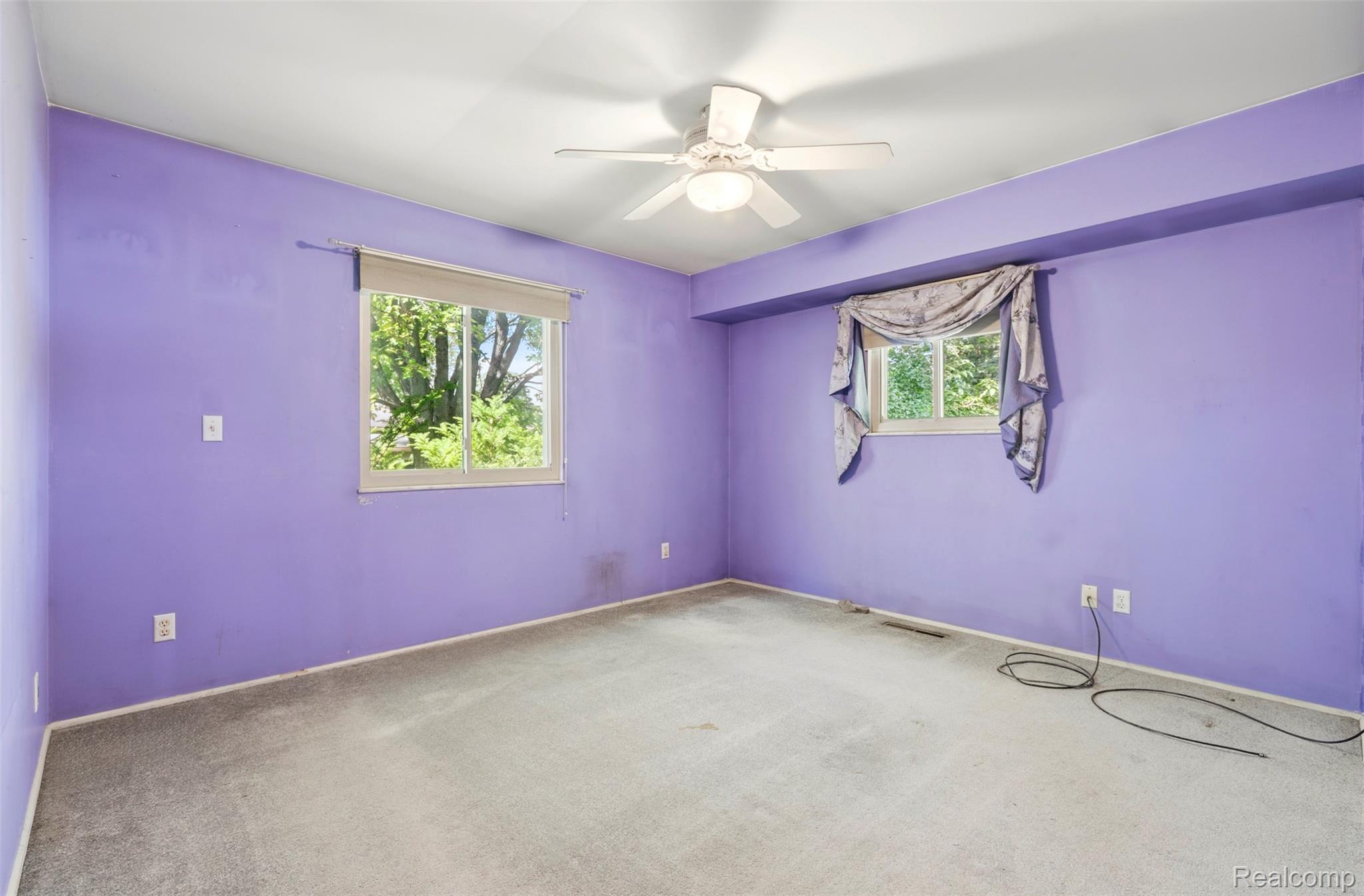 309 Windy Bluff Street Flushing, MI 48433 - Photo 14 of 32 Carpeted room featuring a ceiling fan with integrated lighting, two windows, and a built-in valance over one window