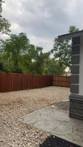 a view of garden with wooden fence