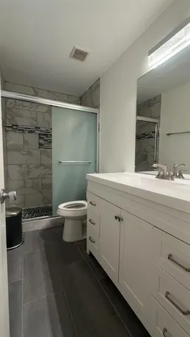 a bathroom with a double vanity sink toilet and shower