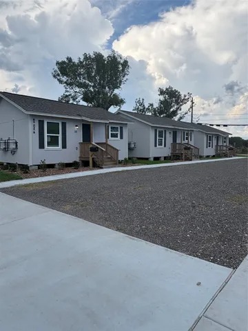 a house view with a sitting space and tree s