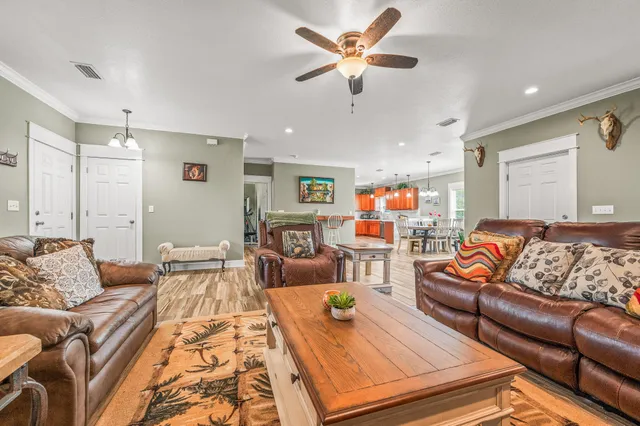 a living room with furniture and a ceiling fan