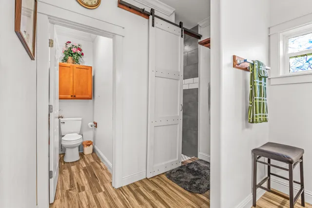 a bathroom with a granite countertop shower a toilet and a window