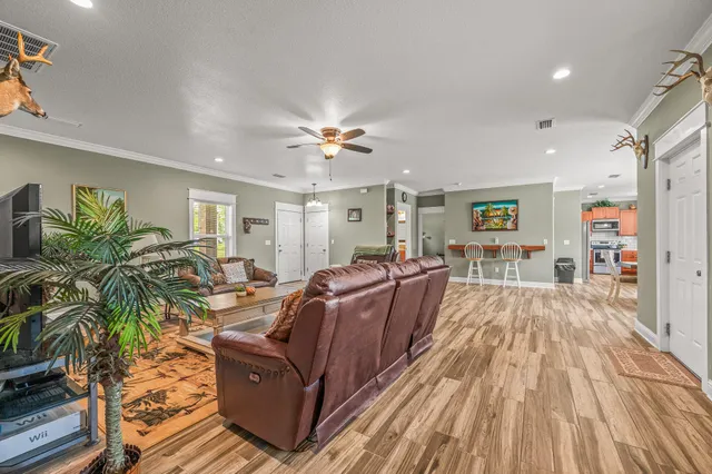a living room with furniture a ceiling fan and a rug