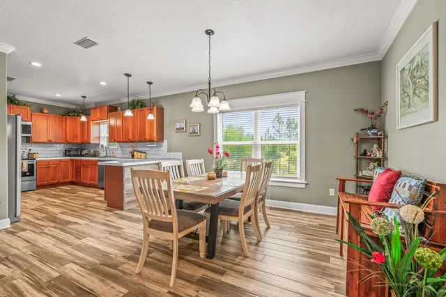 a dining room with furniture a chandelier and wooden floor
