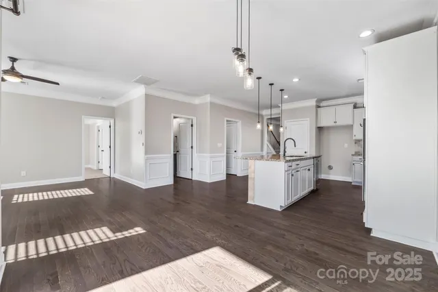 a view of a kitchen with refrigerator and wooden floor