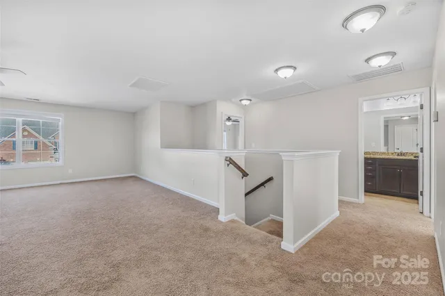 an empty room with windows and refrigerator