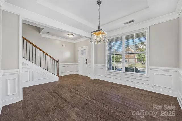 a view of an room with wooden floor ceiling fan and windows