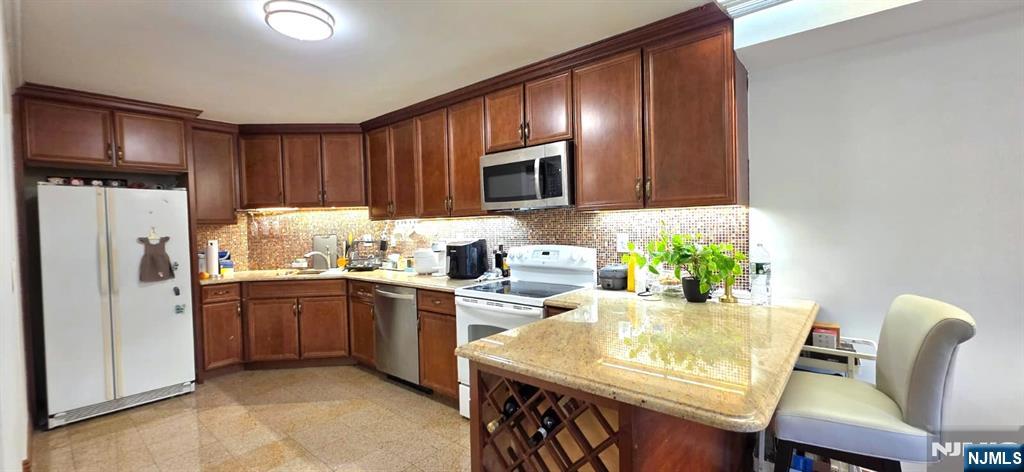 1055 River Road, Unit 302 Edgewater, NJ 07020 - Photo 3 of 17 a kitchen with stainless steel appliances granite countertop a refrigerator a stove top oven a sink dishwasher and white cabinets