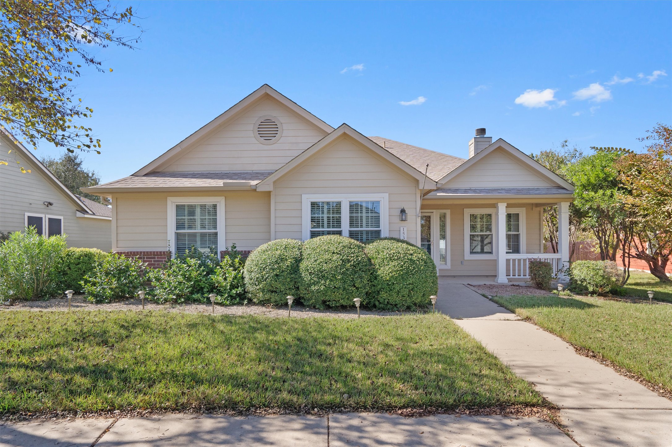 Single-story residence featuring light-colored siding and a covered front porch with white railings