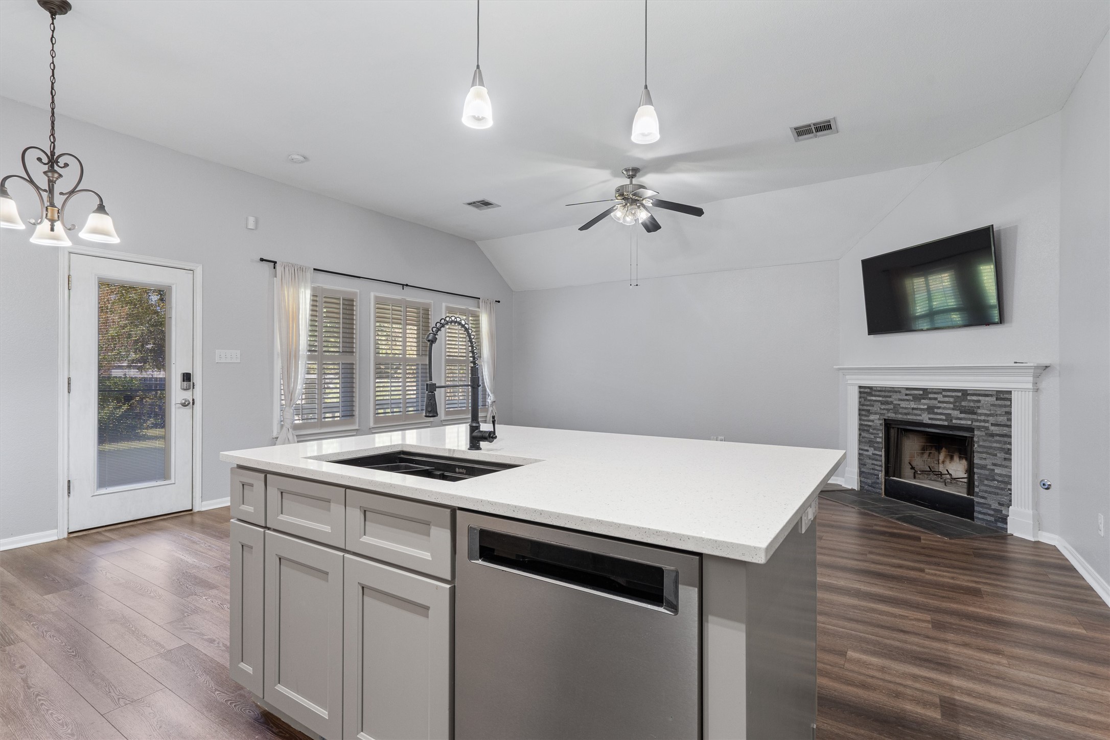 153 Hickory Lane Georgetown, TX 78633 - Photo 13 of 30 Kitchen island featuring a white countertop, undermount sink with a matte black faucet, and integrated stainless steel dishwasher