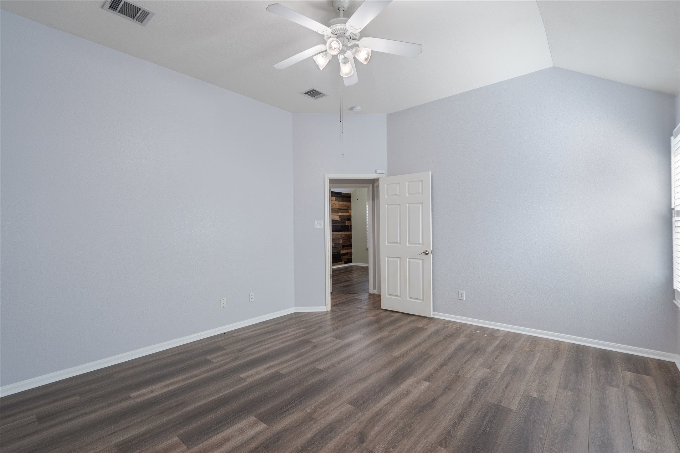 153 Hickory Lane Georgetown, TX 78633 - Photo 15 of 30 Room with wood-finish flooring, vaulted ceiling, and a ceiling fan with integrated lighting