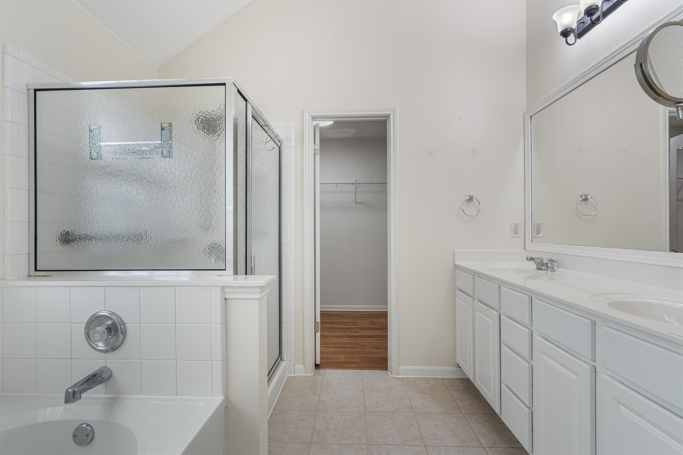 153 Hickory Lane Georgetown, TX 78633 - Photo 17 of 30 Bathroom featuring a double vanity with ample storage, a framed mirror, and an adjacent shower with a textured glass enclosure