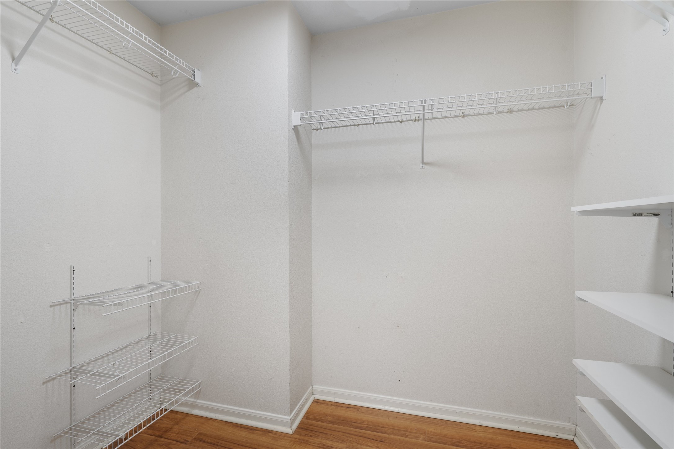 153 Hickory Lane Georgetown, TX 78633 - Photo 19 of 30 Walk-in closet featuring wire shelving, fixed hanging rods, and wood-finish flooring
