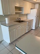 435 South Gulfstream Avenue, Unit 906 Sarasota, FL 34236 - Photo 6 of 22 a kitchen with granite countertop white cabinets and stainless steel appliances