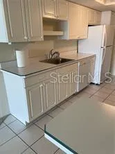 a kitchen with granite countertop white cabinets and stainless steel appliances