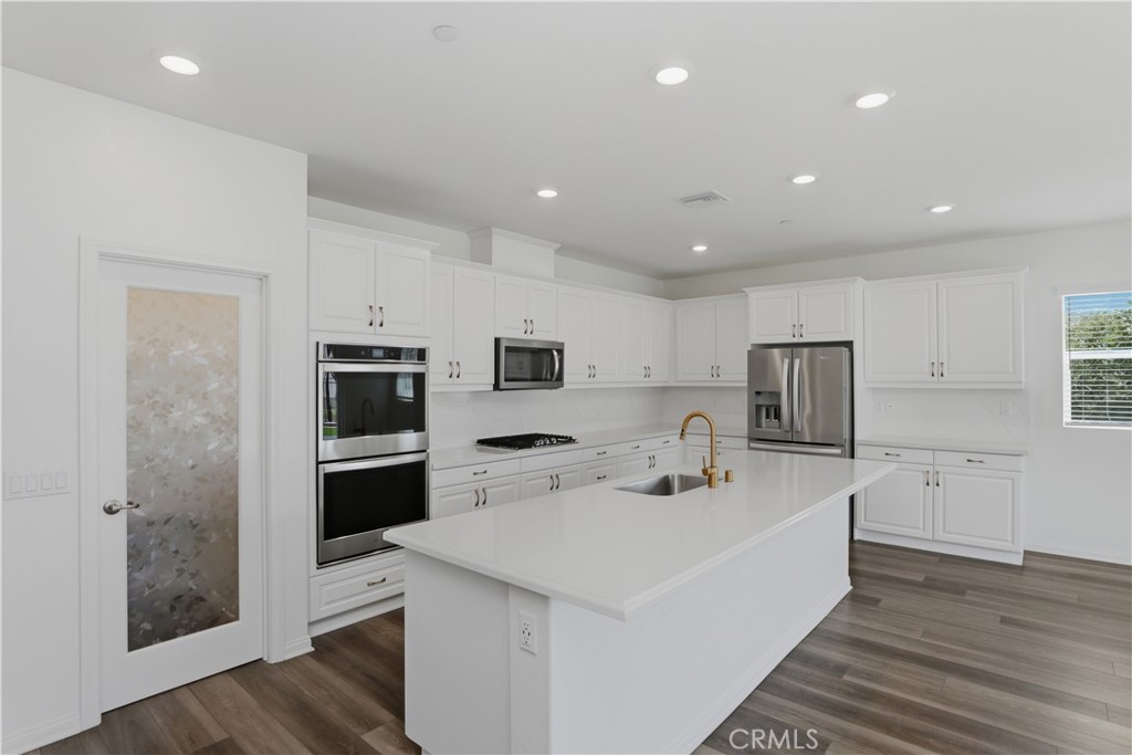 21159 Blue Jeans Court Riverside, CA 92507 - Photo 23 of 63 a kitchen with a sink a counter top space stainless steel appliances and cabinets