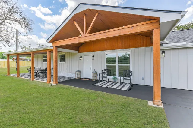 a backyard of a house with table and chairs