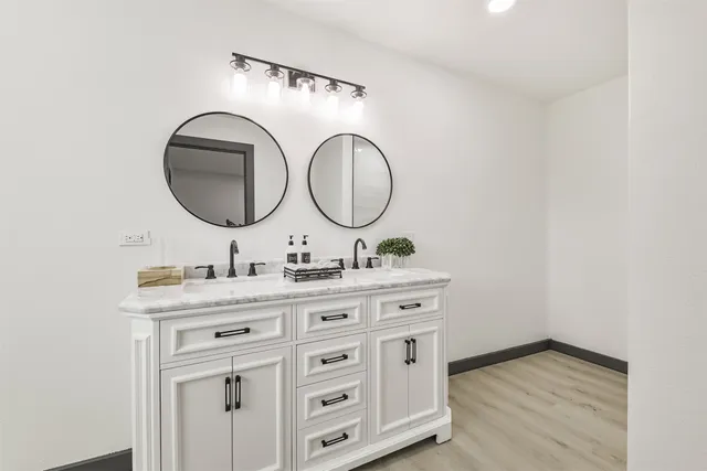 a bathroom with a granite countertop sink and a mirror