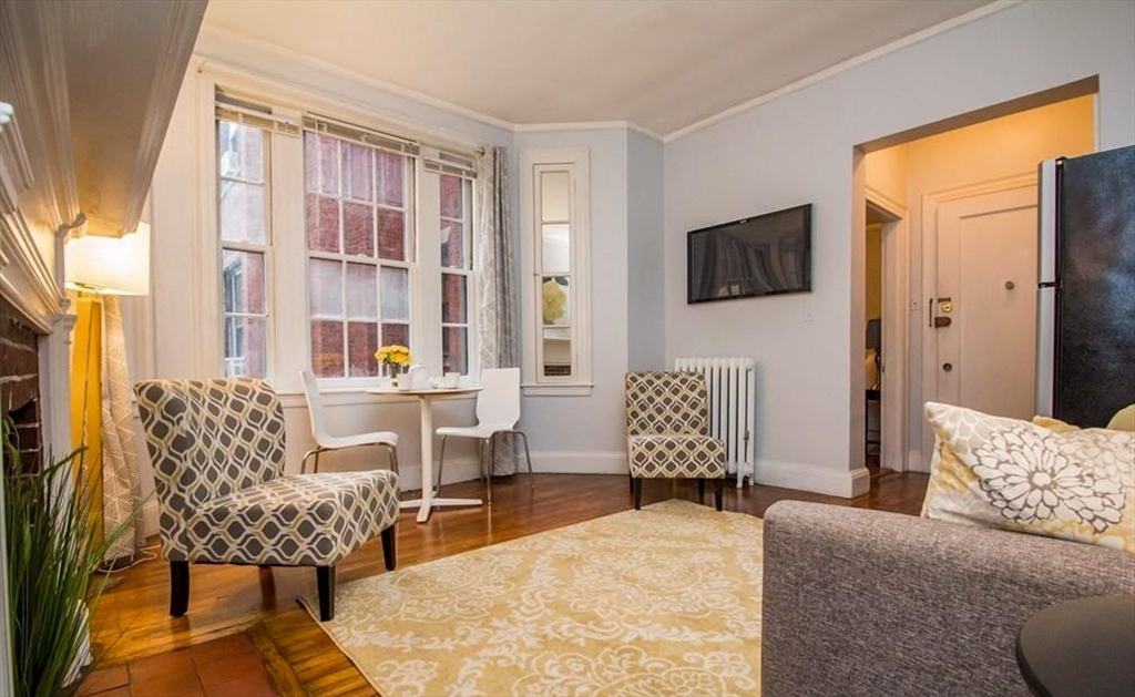 1253 Beacon Street, Unit A5 Brookline, MA 02446 - Photo 2 of 5 a bedroom with furniture and a window